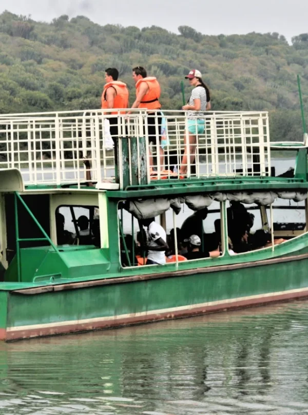 Travelers enjoying a scenic boat cruise on the Kazinga Channel with wildlife along the banks