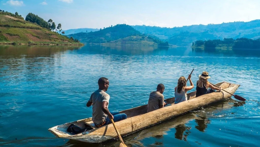 Local Ugandan guides canoeing with tourists across Lake Bunyonyi’s island-dotted waters