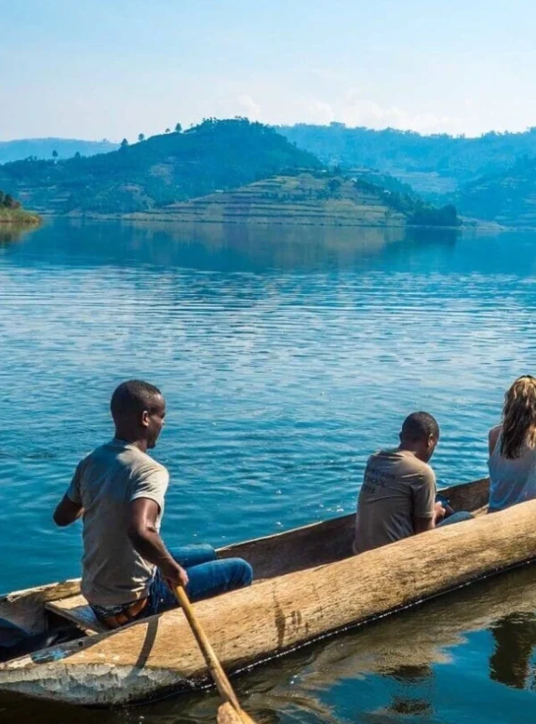 Local Ugandan guides canoeing with tourists across Lake Bunyonyi’s island-dotted waters