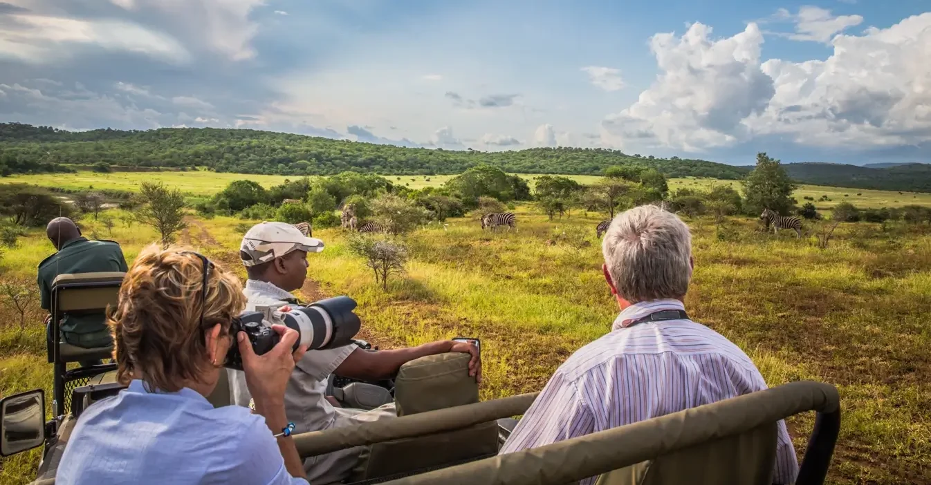 Tourists enjoying a Uganda safari in an open-top van in the wilderness – Uganda safari frequently asked questions