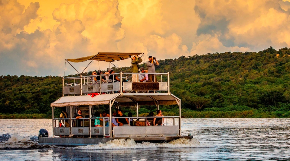 Golden hour boat cruise on the Nile in Murchison Falls National Park, with warm light reflecting on the water and silhouetted wildlife along the banks.