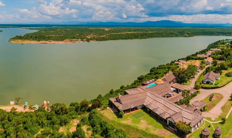 Drone shot of Mweya Safari Lodge surrounded by bushland and overlooking Kazinga Channel