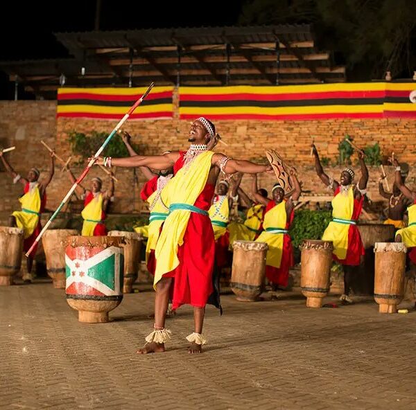 A brightly colored photograph capturing a lively cultural dance at Ndere Cultural Center in Kampala, showcasing traditional attire and energetic movement.